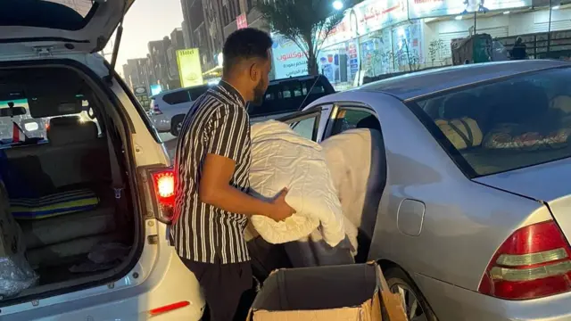 Volunteers loading bedding for people who fled their homes