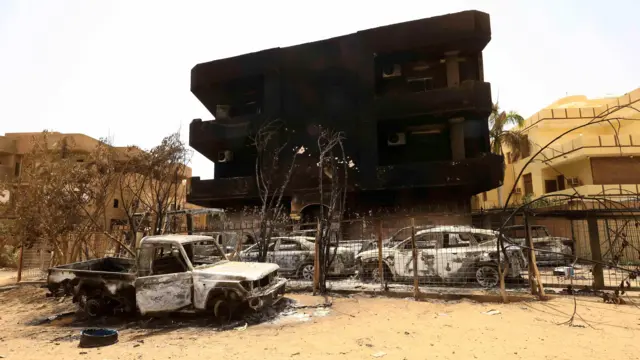 Damaged cars and buildings are seen at the central market in Khartoum North