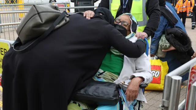 People embrace as they arrive at Stansted Airport