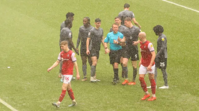 Rotherham and Cardiff players in a downpour