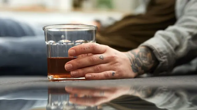 Hand holding a glass of liquid