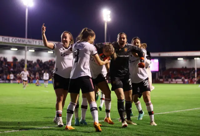 Man United celebrate their win with the travelling fans.