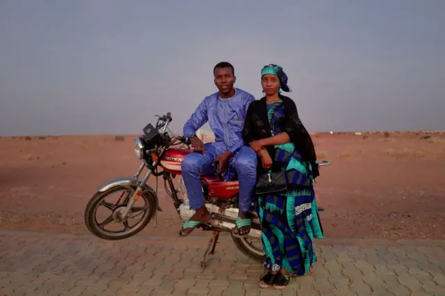 A couple pose next to a motorbike near Agadez in Niger.