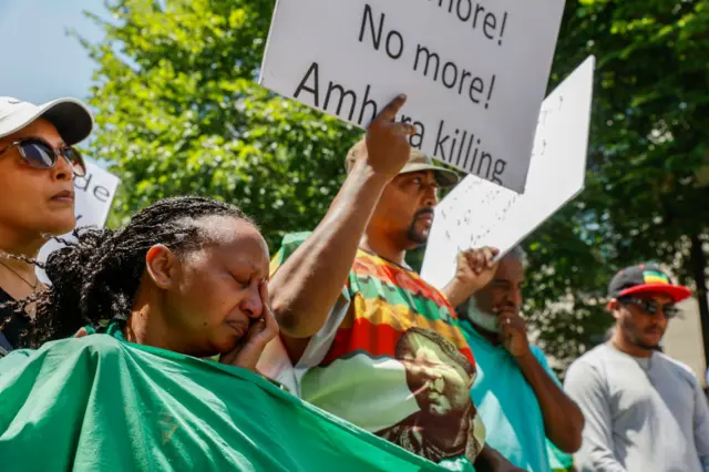 A woman from the Ethiopian community cries alongside other community members during a demonstration to bring awareness to the mass ethnic cleansing of ethnic Amharas in the Gimby Zone in Western Wollege, Oromia Region in Ethiopia on June 30, 2022 in Washington, DC.