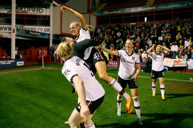 Millie Turner is lifted into the air by her teammates.