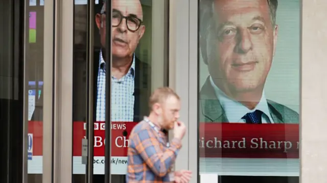 A screen showing a news report through the windows of the BBC in central London