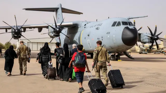 People with suitcases board an aeroplane