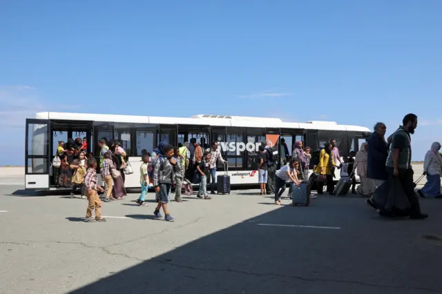 People get off an airport bus in Larnaca