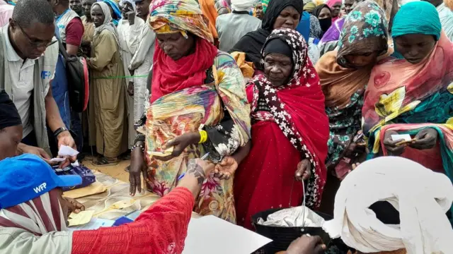 A crowd of women who've fled Sudan in a queue