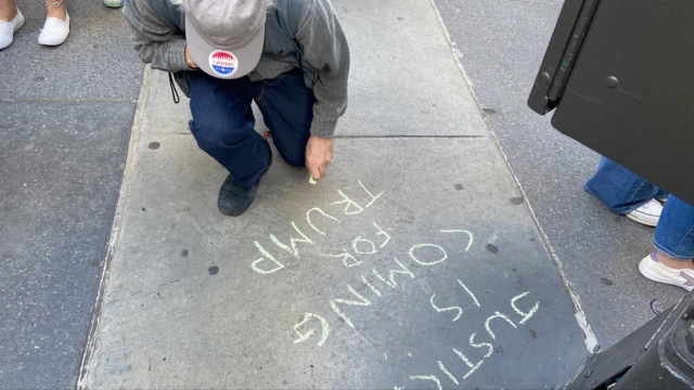 Supporter writing a message on sidewalk