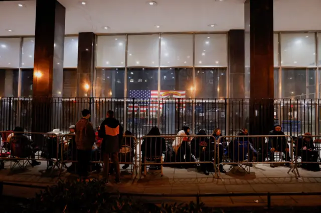 Reporters, photographers and line holders for news agencies wait in line to get into the Manhattan Criminal Courthouse