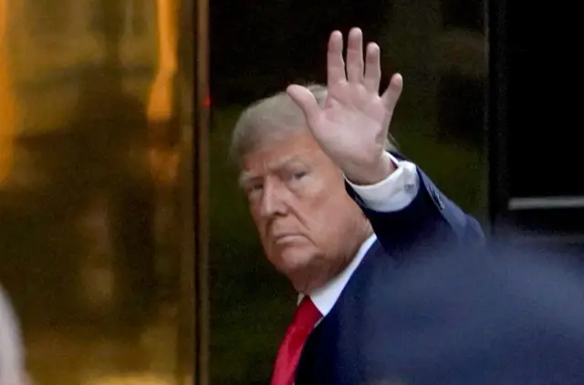 Donald Trump waves to the crowd as he arrives at Trump Tower in New York