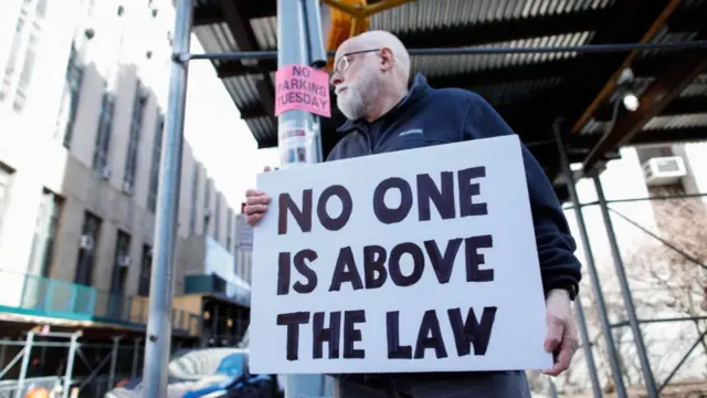 A protester with an anti-Trump poster