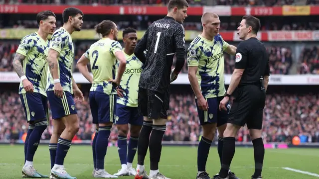 Leeds United players surround the referee
