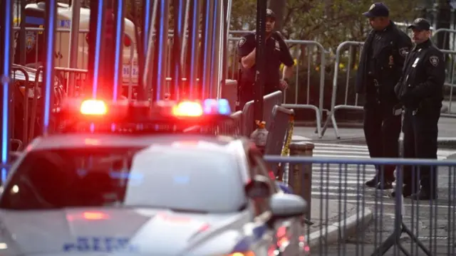 Policemen wait on a closed off street outside the Manhattan Court