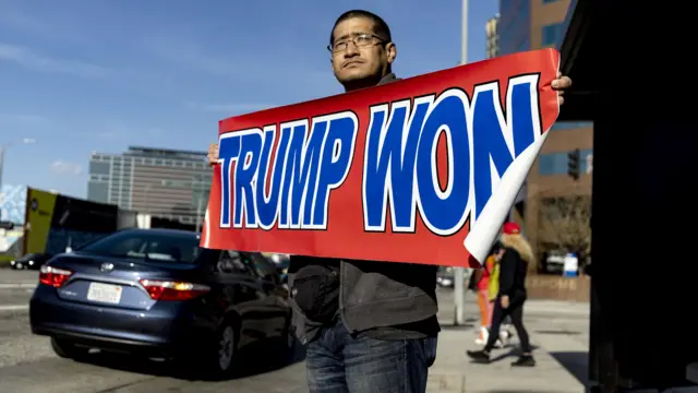 Supporters welcome Trump back to Florida. A man holds a sign reading "Trump won"