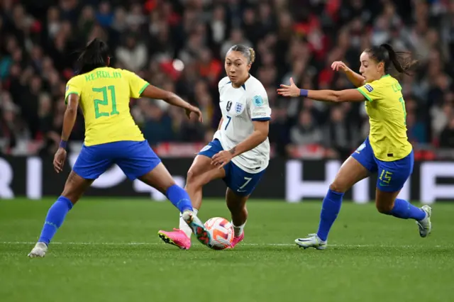 Lauren James drives at the Brazil backline.