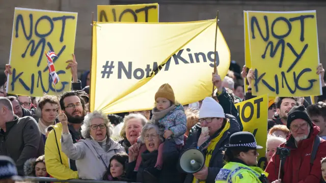 People hold banners saying Not My King