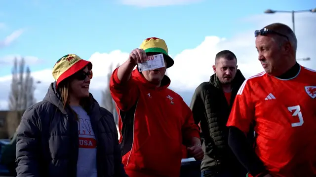 A Wales fan shows off his ticket for tonight's match