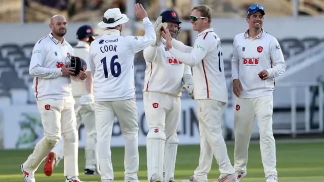 Simon Harmer of Essex celebrates with his team mates after taking the wicket of Luke Hollman