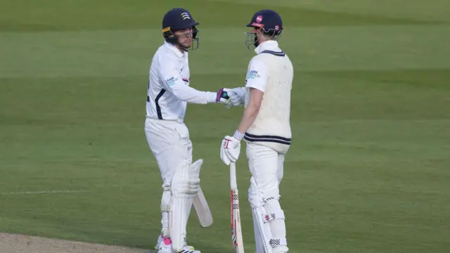 Ryan Higgins is congratulated by John Simpson on reaching his half century for Middlesex against Essex