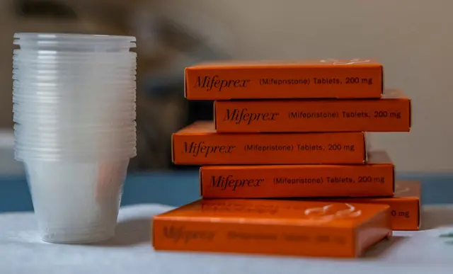 A side-on view of a small stack of boxes containing abortion pill mifepristone