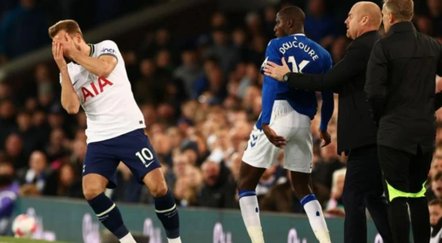 Harry Kane reacts to Abdoulaye Doucoure's hand to the face at Everton