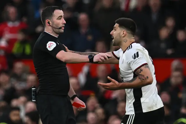 Fulham's Serbian striker Aleksandar Mitrovic (R) argues with English referee Chris Kavanagh (L) and gets himself sent off during the English FA Cup quarter-final football match between Manchester United and Fulham at Old Trafford in Manchester