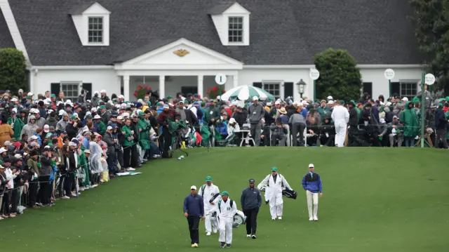 Players walk off the first tee