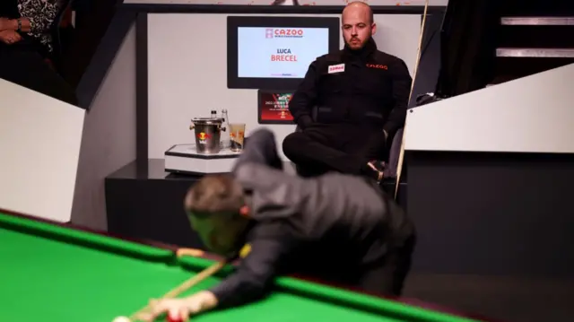 Luca Brecel watches Mark Selby play a shot