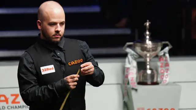 Luca Brecel chalks his cue