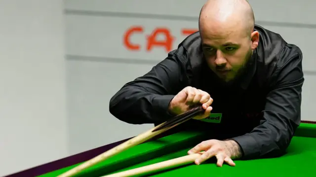 Luca Brecel plays a shot with the rest