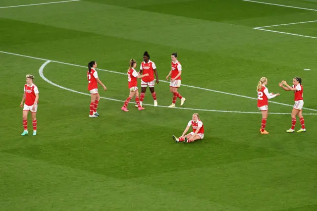 Arsenal players fall to the floor after defeat.