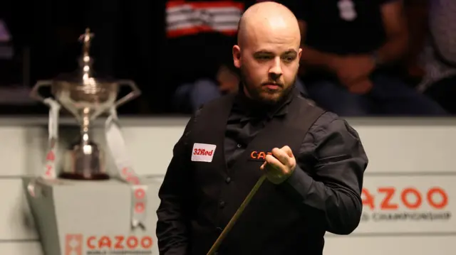 Luca Brecel chalks his cue