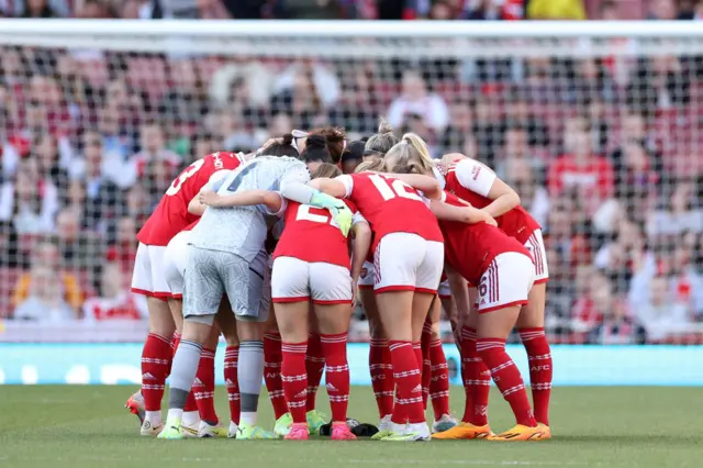 Arsenal players huddle together before kick off.