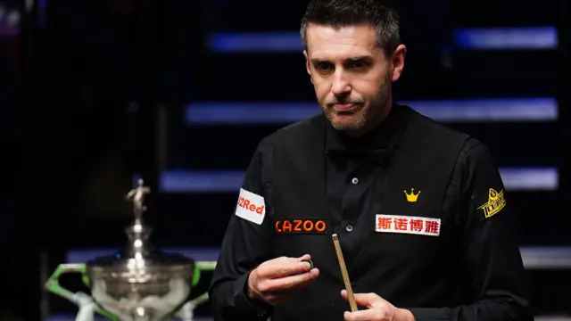 Mark Selby chalks his cue