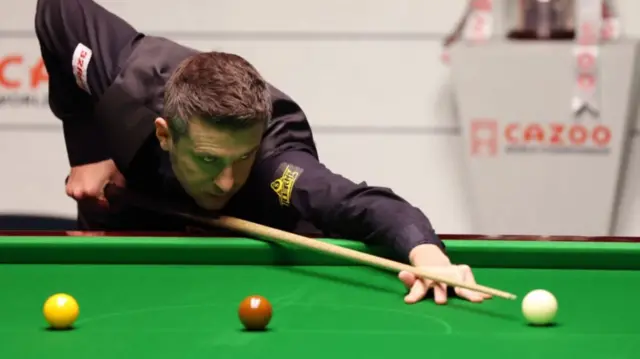 Mark Selby plays a shot