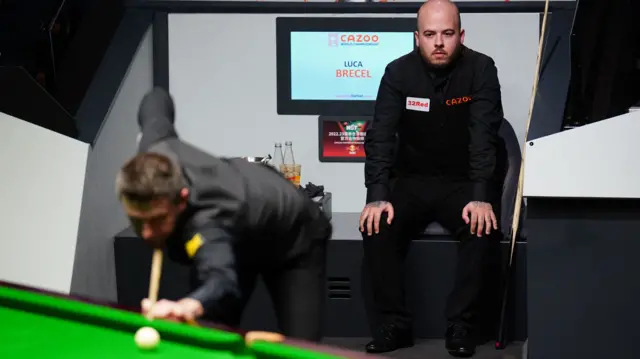 Luca Brecel watches Mark Selby play a shot