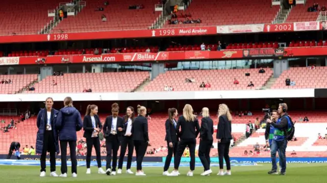 Wolfsburg's players take a look at the Emirates Stadium pitch