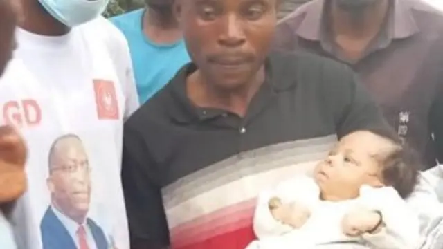 A man holds babies rescued from floods in DR Congo