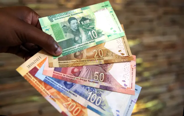 A man holds new South African banknotes at the value of ten, twenty, fifty, one hundred and two hundred South African Rand depicting former South African president Nelson Mandela at The South African Reserve Bank (SARB) on July 13, 2018