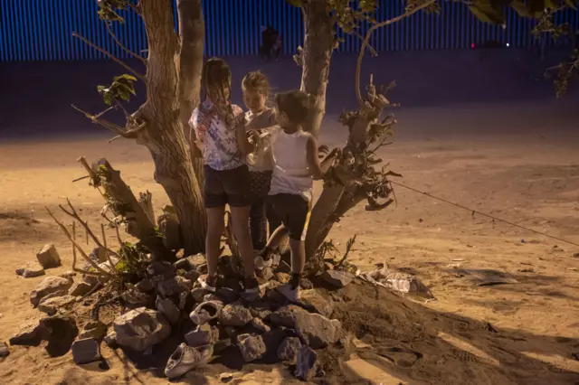 Immigrant children play near the US-Mexico border