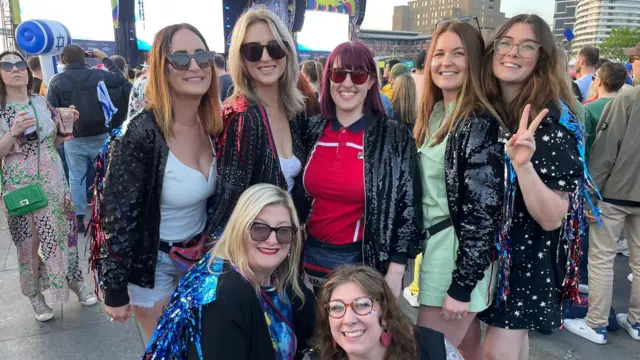 Women wearing sequined jackets outside the arena