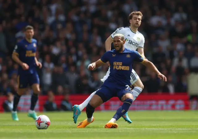 Joelinton and Bamford battle for possession.