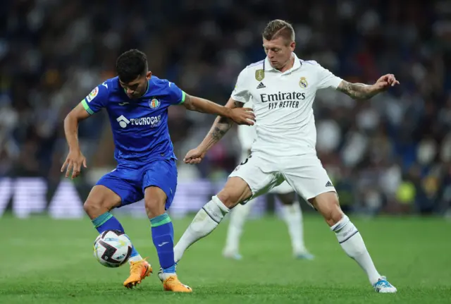 Toni Kroos challenges for the ball.