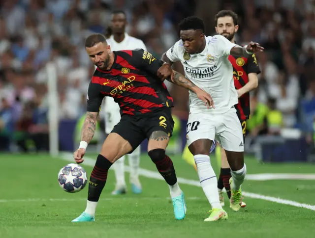 Vinicius Jr battles Kyle Walker for the ball.