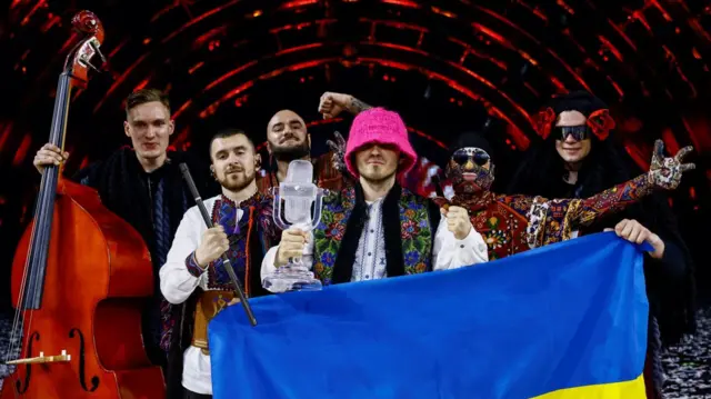 Ukraine’s Kalush Orchestra pose with the Ukrainian flag