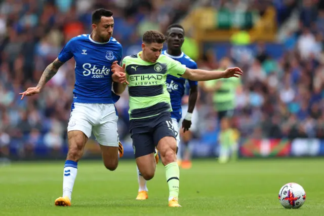 Julian Alvarez of Manchester City is challenged by Dwight McNeil of Everton