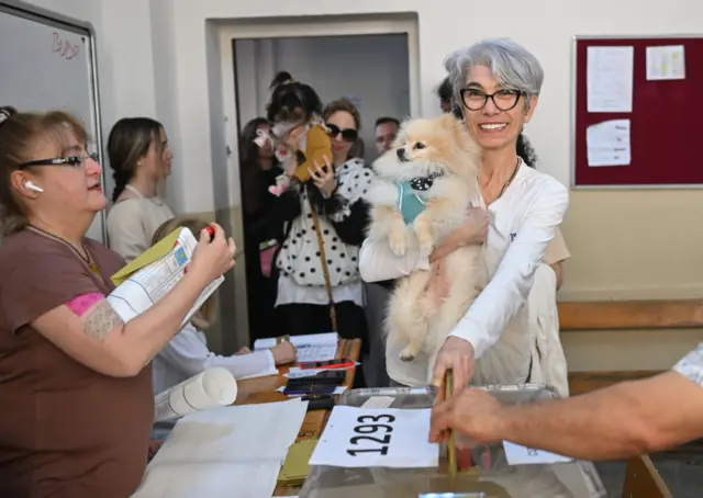 A voter casts a ballot with her dog, for the presidential and parliamentary elections in Izmir, Turkiye on May 14, 2023