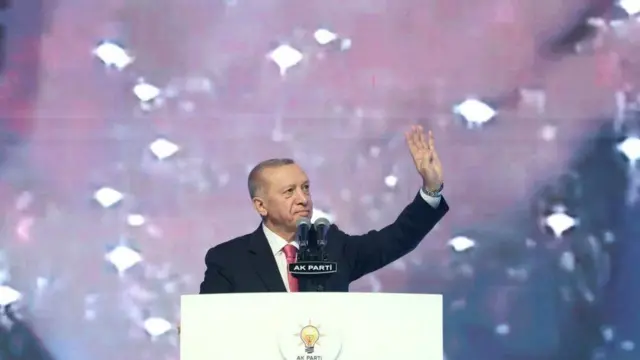 Turkish President Tayyip Erdogan greets the audience during a meeting of his ruling AK Party to announce the party's election manifesto ahead of the May 14 elections